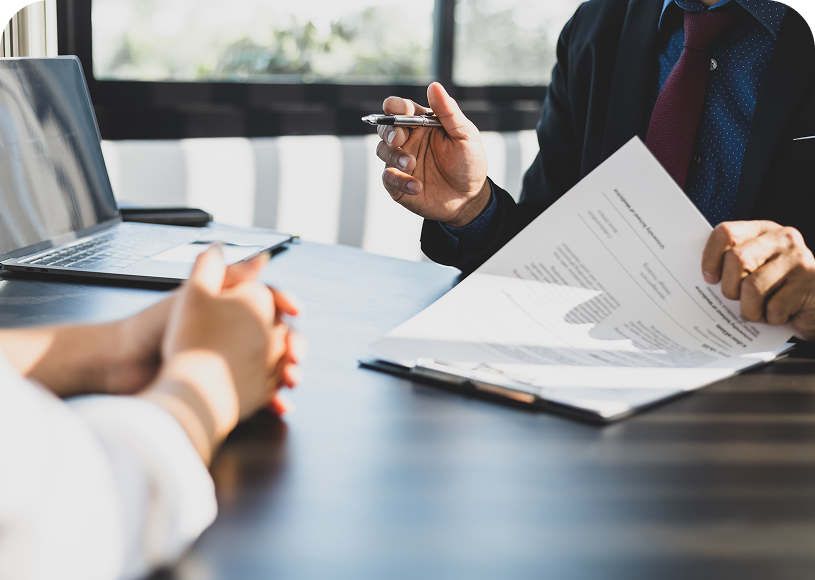 Two people discussing paperwork at office